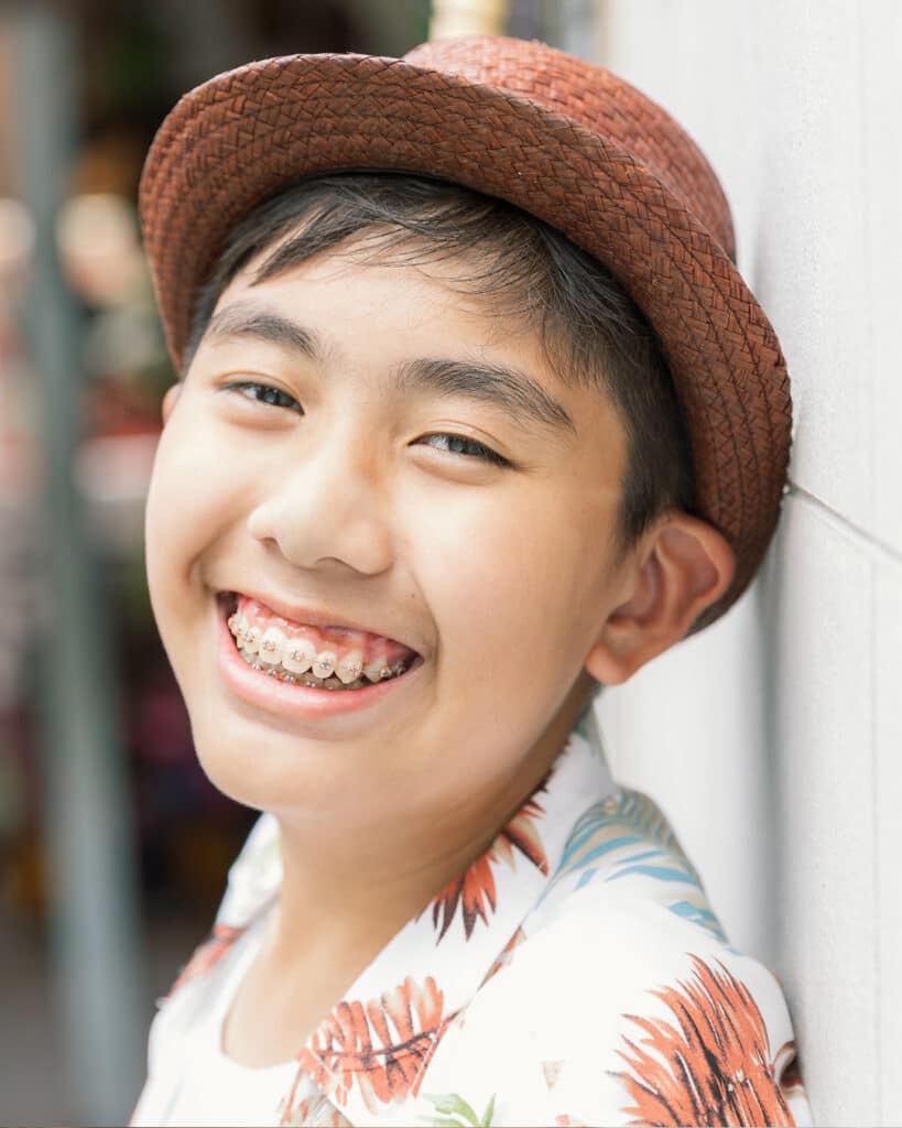 smiling boy with hat and braces